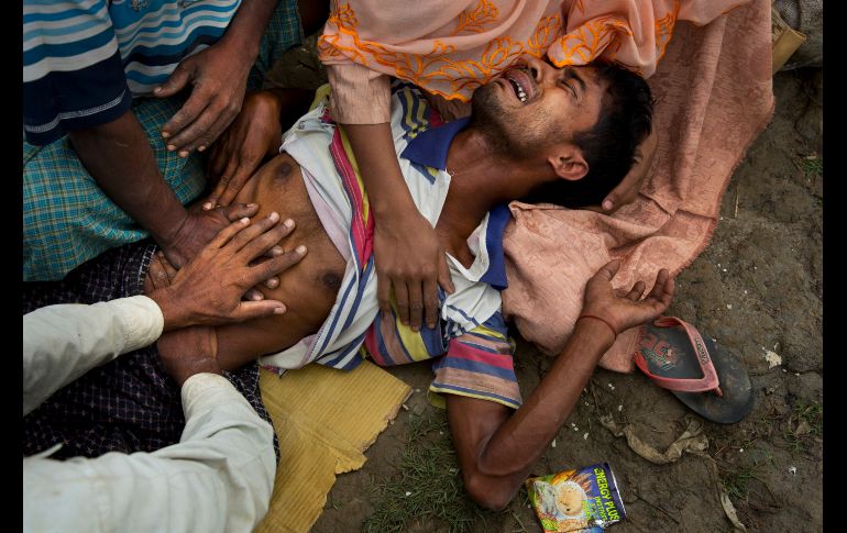 Muhammed Yunus, un rohinyá de 28 años, se queja de dolor luego de no haber comido en tres días. Él y otros rohinyás que huyeron de Brimania aguardan permiso para cruzar hacia campamentos de refugiados en Bangladesh. AP/B. Armangue