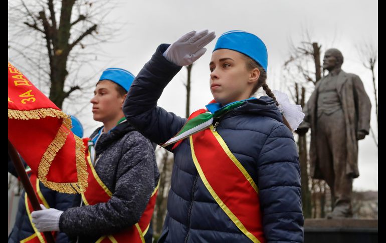 Integrantes de la organización juvenil Pioneros Bielorrusos saludan frente al monumento a Vladimir Lenin, en una ceremonia por el centenario de la revolución bolchevique. AP/S. Grits