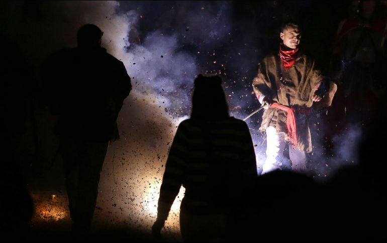 Los participantes de la marcha queman los efigies que portaron durante su caminata. AFP/D. Leal