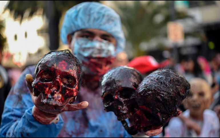 En el Zócalo, los zombies se mezclaron con las decenas de familias que disfrutaban la exhibición de calaveras gigantes. AFP / Y. Cortez