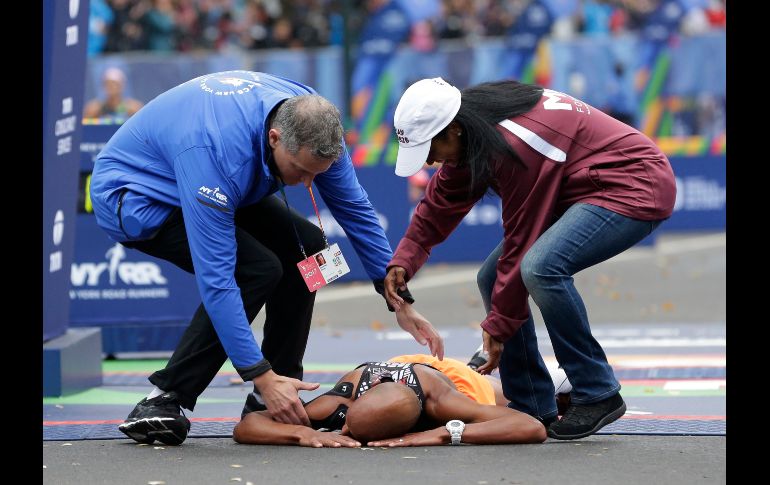 Hombres auxilian al corredor Meb Keflezighi, quien colapsó tras cruzar la meta del maratón de Nueva York. AP/S. Wenig