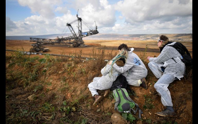 Activistas observan mientras policías impiden que otros medioambientalistas avancen en una marcha para entrar a una mina de lignito cerca de Elsdorf, Alemania, en protesta contra de las energías basadas en fósiles. AFP/S. Schuermann