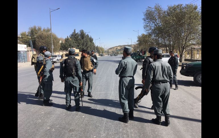 Guardias de seguridad afganos toman posiciones en las cercanías del sitio afectado, en donde el asalto continúa a pesar de que uno de los atacantes fue abatido. AFP/S. Marai