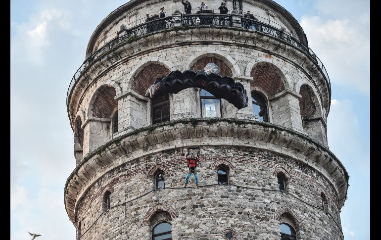 El atleta del deporte extremo Cengiz Kocak realiza un salto BASE de la torre Galata en Estambul, Turquía. Kocak aterrizó a salvo tras saltar en paracaídas desde 36 metros de altura. AFP/O. Kose