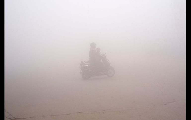 Una mujer conduce una moto en Nueva Delhi, India, entre una capa de neblina contaminante.La ciudad volverá a limitar el tráfico a días alternos en función de la matrícula de los vehículos durante la próxima semana. AP/R S Iyer