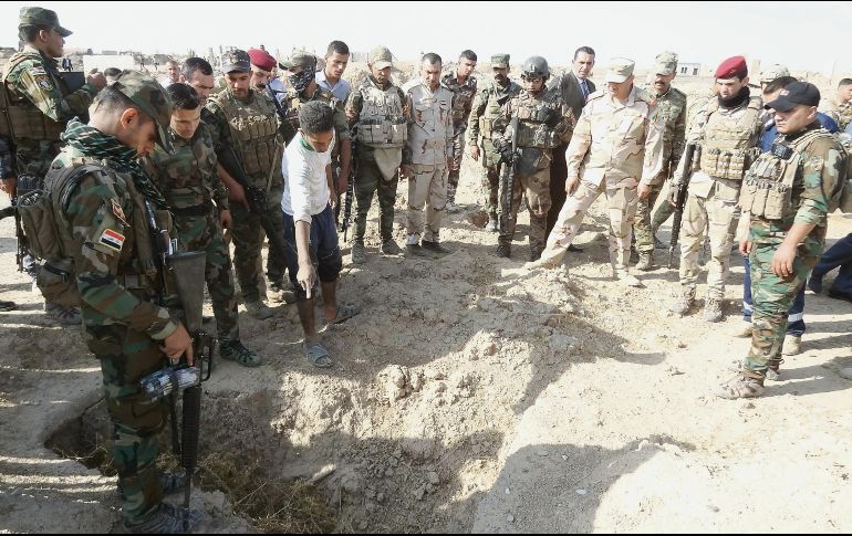 Cuerpos. Fuerzas iraquíes inspeccionan la zona de una fosa clandestina atribuida a los radicales del Estado Islámico, en el Distrito de Hawija. AFP