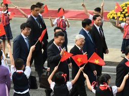 Xi Jinping (C) y el secretario general del Partido Comunista de Vietnam, Nguyen Phu Trong (R) saludan durante una ceremonia de bienvenida en el palacio presidencial en Hanoi. EFE/H. Dinh Nam