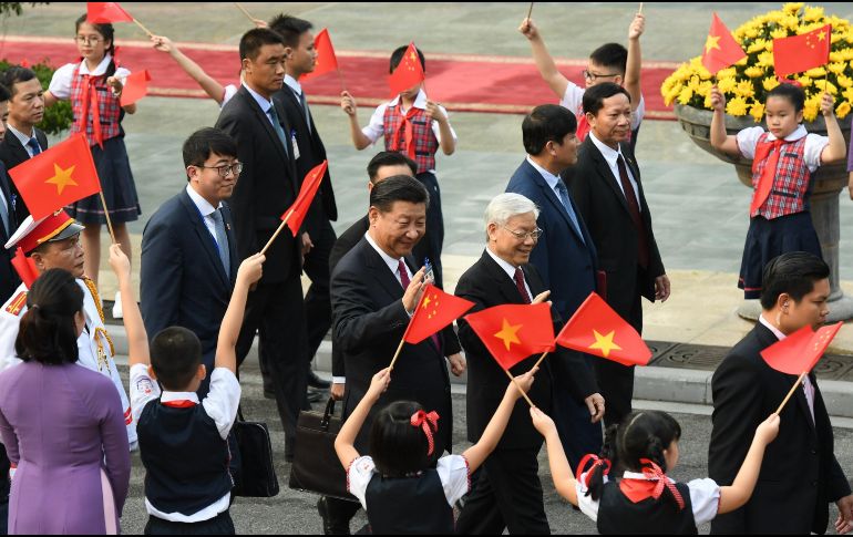 Xi Jinping (C) y el secretario general del Partido Comunista de Vietnam, Nguyen Phu Trong (R) saludan durante una ceremonia de bienvenida en el palacio presidencial en Hanoi. EFE/H. Dinh Nam