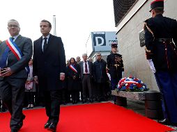 Emmanuel Macron (2i), y el alcalde de Saint-Denis, Laurent Russier (i), conversan tras depositar una corona de flores ante una placa conmemorativa colocada a las puertas del Estadio de Francia. EFE/P. Wojazer