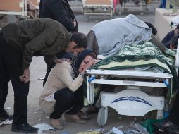 Varias personas lloran junto a uno de los cuerpos rescatados esta mañana. AFP/F. Menati