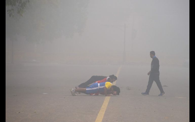Personas se ejercitan enter una capa de contaminación en Nueva Delhi, India. AFP/D. Faget
