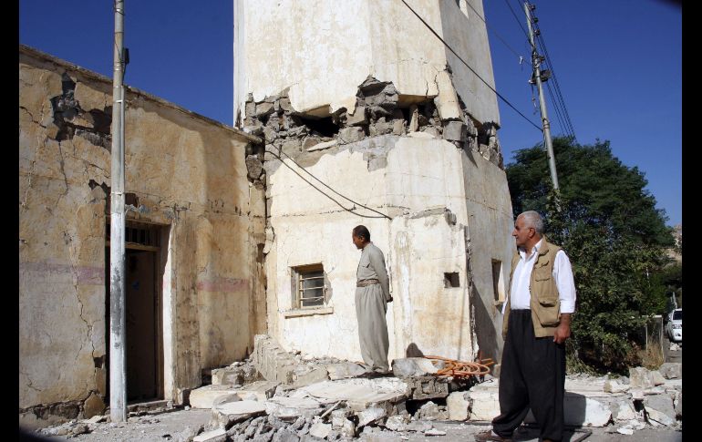 Habitantes inspeccionan un edificio dañado en Darbandikhan.