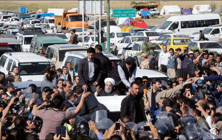 El presidente iraní, Hasán Rouhaní (c), saluda desde su vehículo durante su visita a la zona afectada por el terremoto que asoló hace dos días la ciudad de Pole-Zahab. EFE/A. Taherkenareh