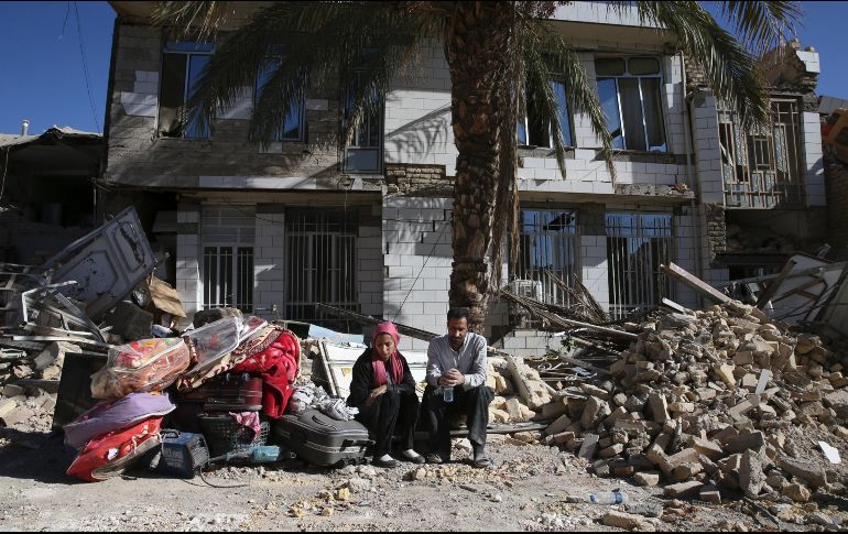 Dos personas frente a su casa destruida por el sismo del domingo en Irán. AP/ V. SALEMI