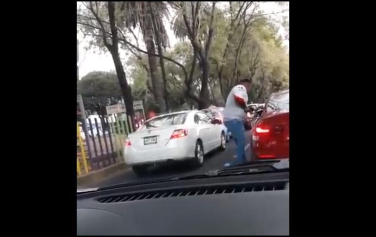 En un breve video subido a redes sociales, se observa cuando el sujeto se encuentra de pie junto a la ventana del conductor de un auto rojo. TWITTER / @gabogrizzly