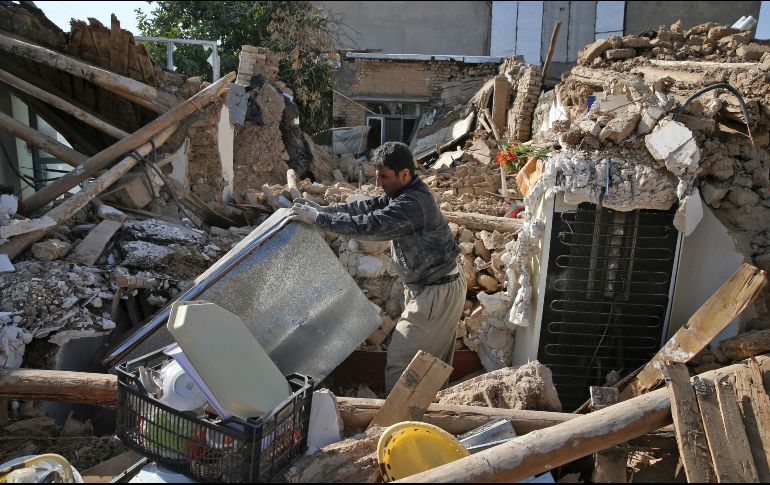 Un hombre rescata sus pertenencias de su hogar, que se derrumbó tras el terremoto. AP/A. Salemi