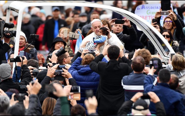 El Papa Francisco besa a un niño a su llegada a su audiencia general de los miércoles. EFE/E. Ferrari