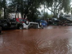 Coches destrozados por las inundaciones permanecen agolpados en calles del centro de Mandra. EFE/P. Saitas