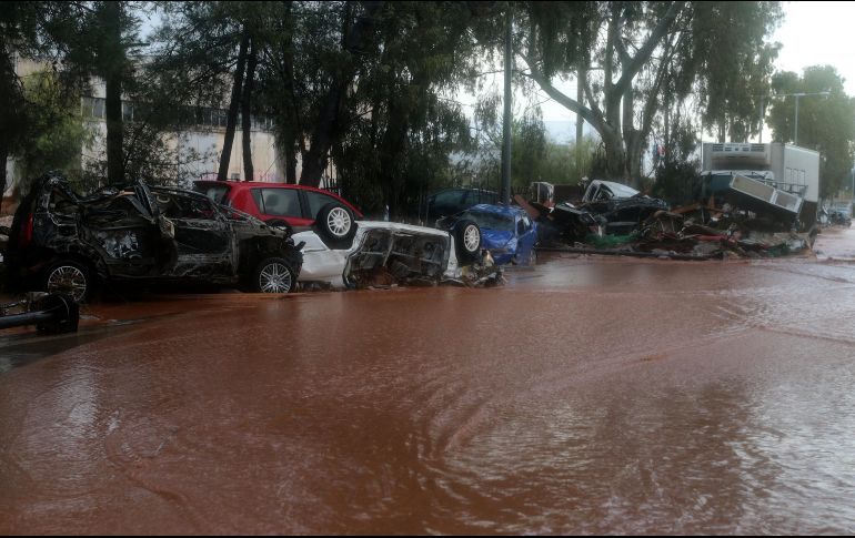 Coches destrozados por las inundaciones permanecen agolpados en calles del centro de Mandra. EFE/P. Saitas