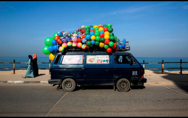 Un vehículo con globos se traslada por una carretera costera en la Ciudad de Gaza, en Territorios Palestinos. AFP/M. Abed