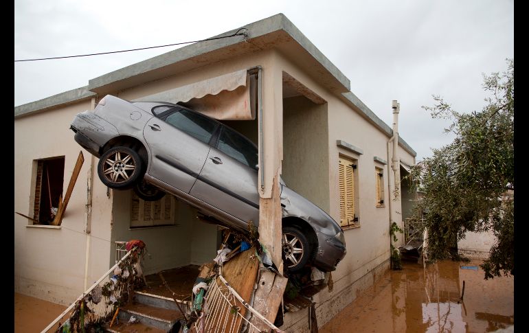 Un auto quedó atascado en una casa tras lluvias torrenciales en la ciudad de Mandra. Grecia estaba el jueves de 