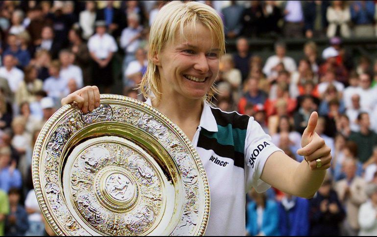 La tenista checa Jana Novotna alza su trofeo, ganado tras vencer ante la francesa Nathalie Tauziat, durante el campeonato de Wimbledon 1998. EFE/ARCHIVO