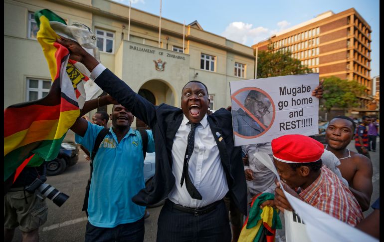 Habitantes de Zimbabue celebran afuera del Parlamento al conocer la noticia de la dimisión del presidente Robert Mugabe. AP / B. Curtis