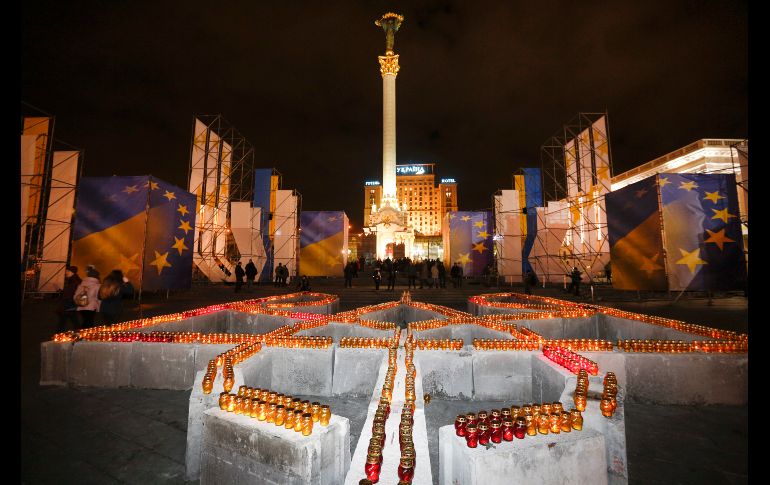 Personas encienden velas en Kiev colocadas en forma de escudo de armas de Ucrania, para rendir homenaje a las víctimas de las protestas antigubernamentales durante los años 2013 y 2014 llamadas la Revolución de la Dignidad. AP / E. Lukatsky