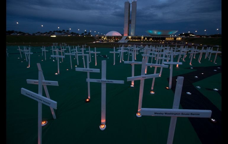 Greenpeace colocó cruces con los nombres de personas asesinadas por defender los bosques de la Amazonía frente al edificio del Congreso Nacional en Brasilia (Brasil). EFE / J. Alves