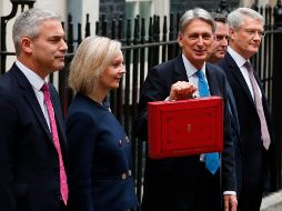 El ministro británico de Finanzas, Philip Hammond posa con los miembros de su equipo mientras muestra el maletín que contiene su proyecto de presupuesto. AFP/A. Denni