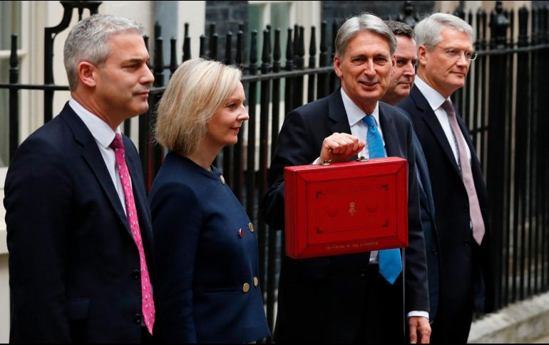 El ministro británico de Finanzas, Philip Hammond posa con los miembros de su equipo mientras muestra el maletín que contiene su proyecto de presupuesto. AFP/A. Denni
