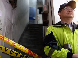 Un policía local hace guardia a la entrada del edificio afectado. AFP/S. Yeh