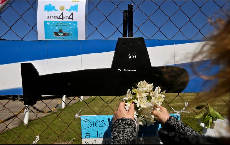 Una mujer coloca flores en una imagen del submarino ARA San Juan en la base naval en Mar de Plata. AP/E. Felix