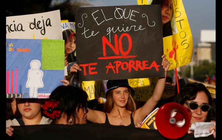 Chilenas muestran carteles referentes a la violencia de pareja. EFE / E. González