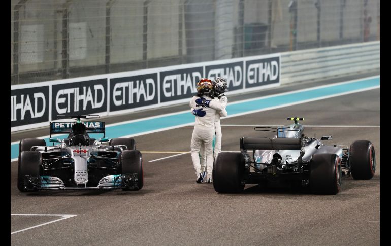 Lewis Hamilton (frente), piloto de Mercedes, celebra con su compañero de equipo Valtteri Bottas al final del Gran Premio de la Fórmula 1 de  Abu Dhabi. Bottas ganó la carrera y Hamilton quedó segundo. AFP/K. Sahib