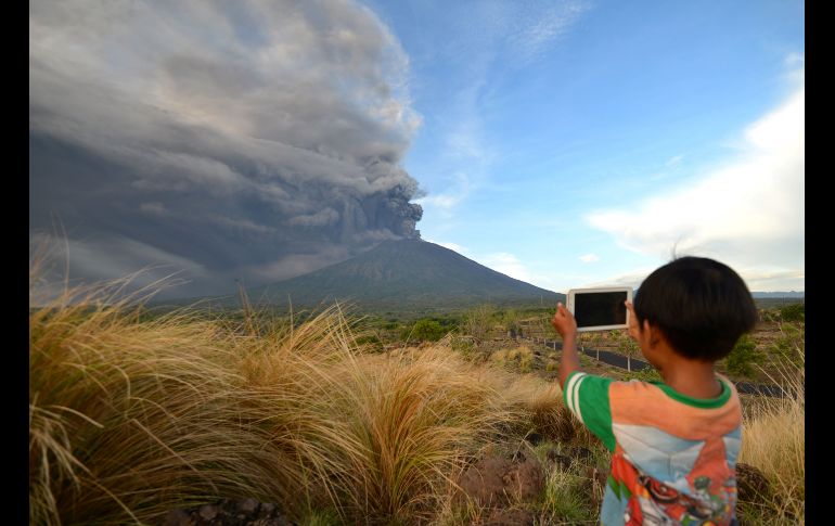 Un niño toma fotos durante una erupción. El Agung se encuentra en el este de la isla de Bali, en el distrito Karangasem y lejos de la mayoría de las atracciones turísticas.