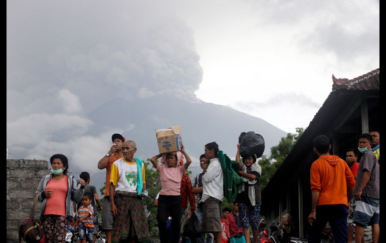 Pobladores cargan sus pertenencias tras evacuar sus casas. Más de 25 mil personas del distrito Karangasem están desplazadas por la alerta de erupción.
