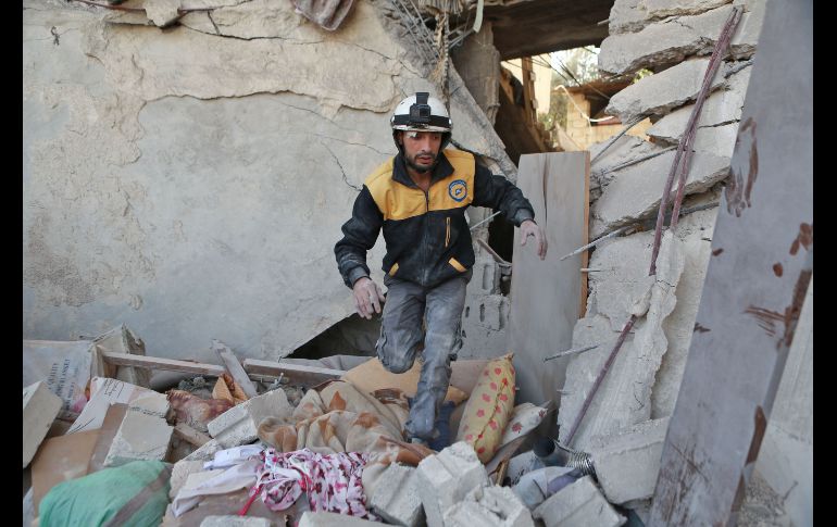 Un voluntario de la defensa civil siria busca sobrevivientes entre los escombros, tras un bombardeo aéreo en Hamouria, ciudad bajo control de los rebeldes. AFP/A. Eassa