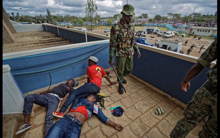 Seguidores del presidente de Kenia, Uhuru Kenyatta, yacen inconscientes tras recibir golpes de policías, luego de que intentaban irrumpir en el estadio Kasarani de Nairobi durante la toma de posesión del mandatario. AP/B. Curtis