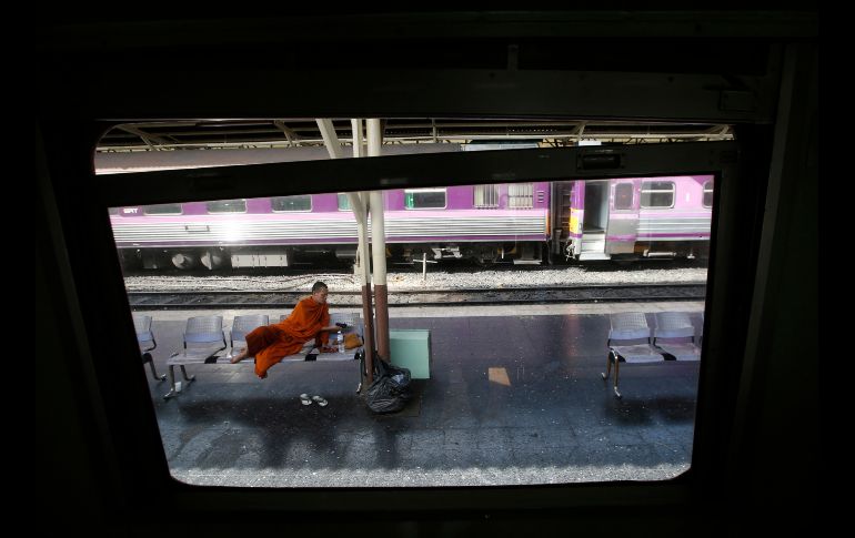 Un monje budista mira su celular en una plataforma de la estación de trenes Hua Lampong en Bangkok, Tailandia. AP/S. Lalit