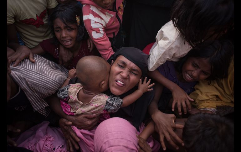 Refugiados rohinyás reaccionan mientras policías intentan controlar la multitud en un centro de ayuda en Cox's Bazar, Bangladesh, durante la entrega de paquetes con alimentos. AFP/E. Jones