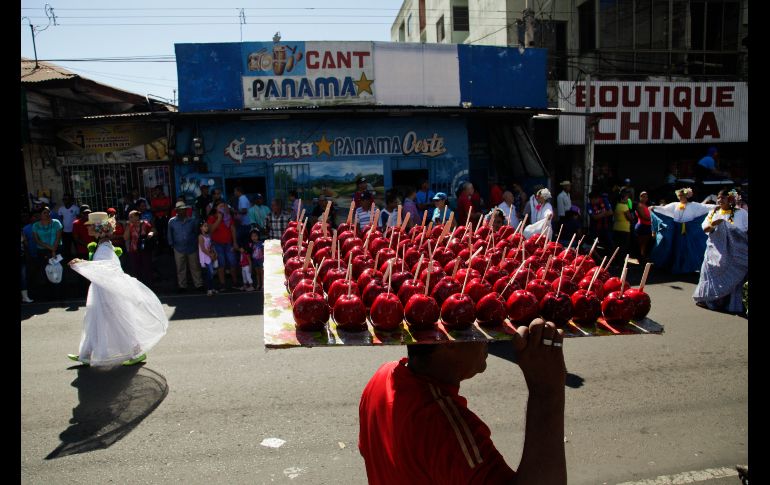 Un vendedor ofrece manzanas acarameladas durante el desfile de la Independencia en La Chorrera, Panamá. AP/A. Franco