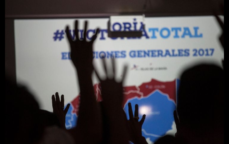 Simpatizantes del presidente de Honduras, Juan Orlando Hernández, forman un cuatro como símbolo de los años de un nuevo mandato, mientras el mandatario explica los resultados preliminares de las elecciones generales. AP/R. Abd