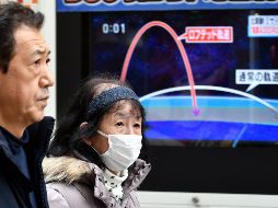 Ciudadanos caminan frente a un televisor en Tokio (Japón) que muestra los detalles del lanzamiento de un misil balístico de Corea del Norte. EFE/F. Robichon