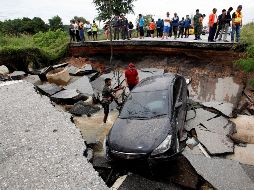 Oficiales tailandeses inspeccionan una carretera derrumbada por las inundaciones causadas por las fuertes lluvias en el distrito de Thepha. EFE/A. Wangni