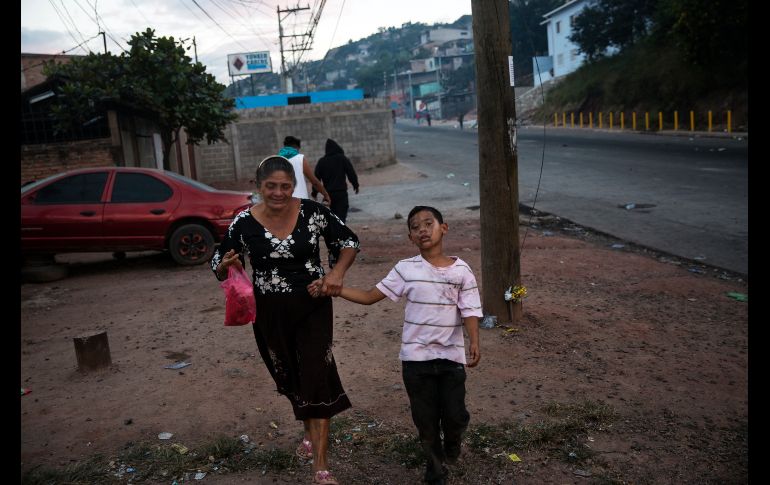 En la represión policial de las protestas en Tegucigalpa, los gases lacrimógenos afectaron incluso a un niño que regresa a casa ayudado por su abuela. AP / F. Antonio