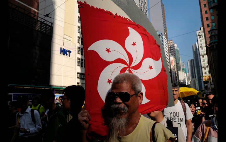 Una manifestante sostiene una bandera de Hong Kong durante una marcha en esa ciudad, en protesta contra el régimen chino y en demanda de la renuncia del secretario de Justicia. AP/V. Yu