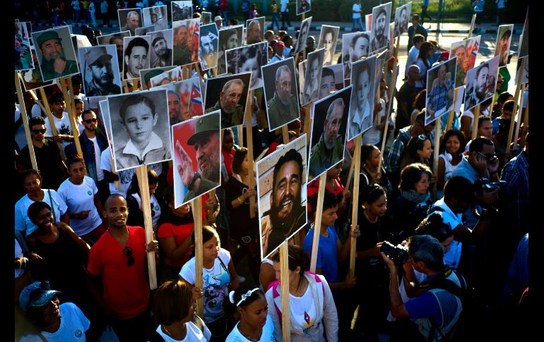 Cubanos llevan fotos del fallecido líder Fidel Castro en una marcha en Santiago, Cuba, para conmemorar el primer año del entierro de sus cenizas en esta ciudad. AP/R. Espinosa