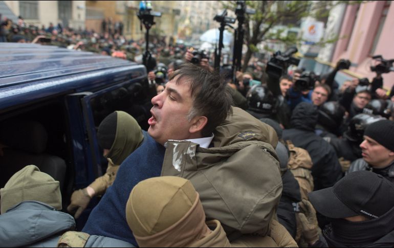 Alrededor de cien personas congregadas alrededor de la vivienda de Saakashvili, situada en el centro de Kiev, intentaron bloquear el paso del vehículo en el que estaba siendo trasladado el político (c). AP/E. Maloletka