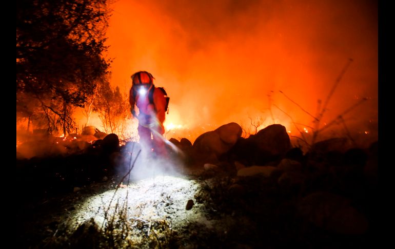 Un bombero combate un incendio en Santa Paula, California, que se mueve hoy 
